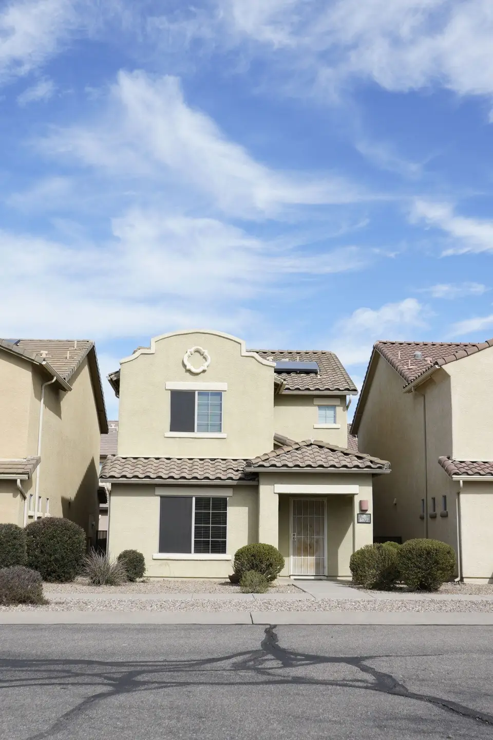 Stucco homes with tile roofs on a quiet street