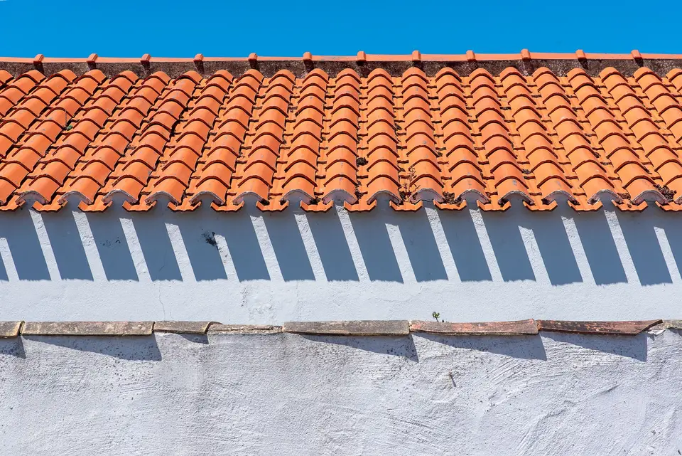 Barrel tile roof over a white stucco wall